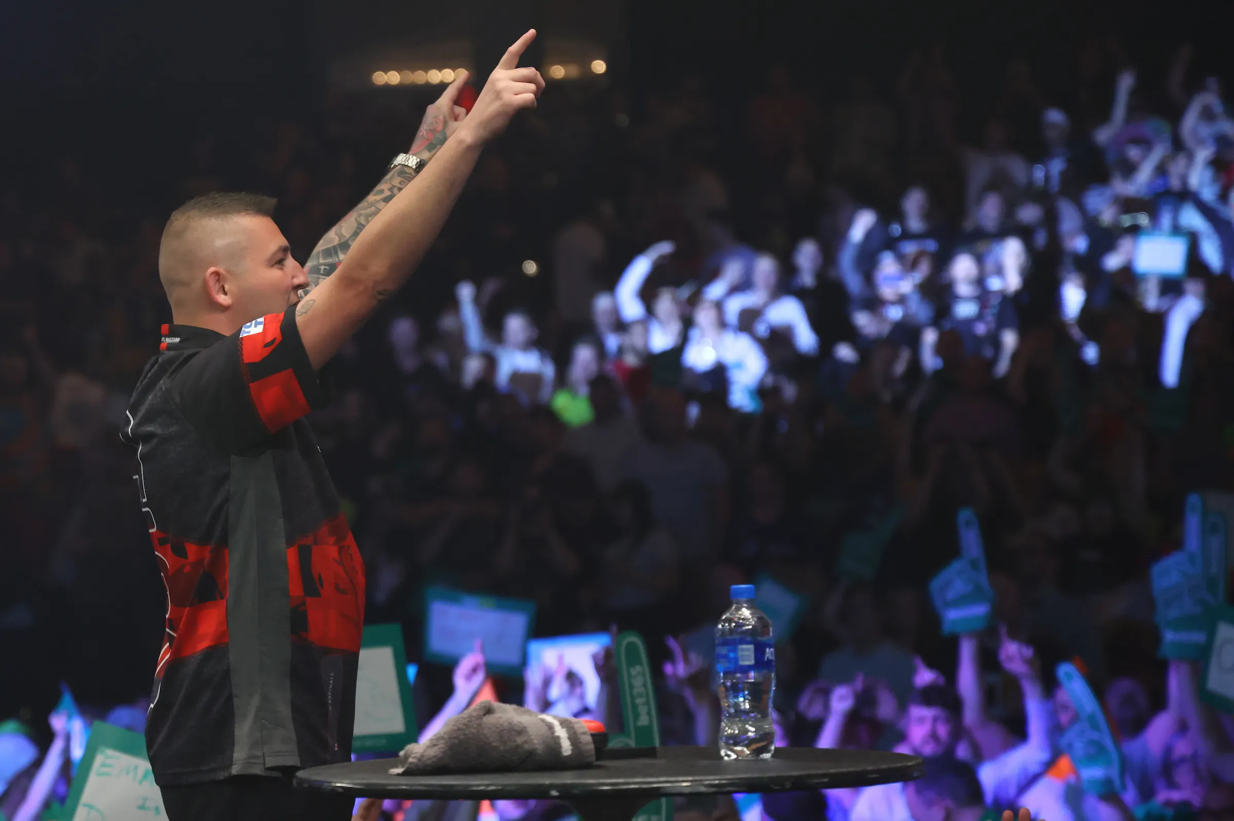 A player celebrating on stage in front of a packed crowd